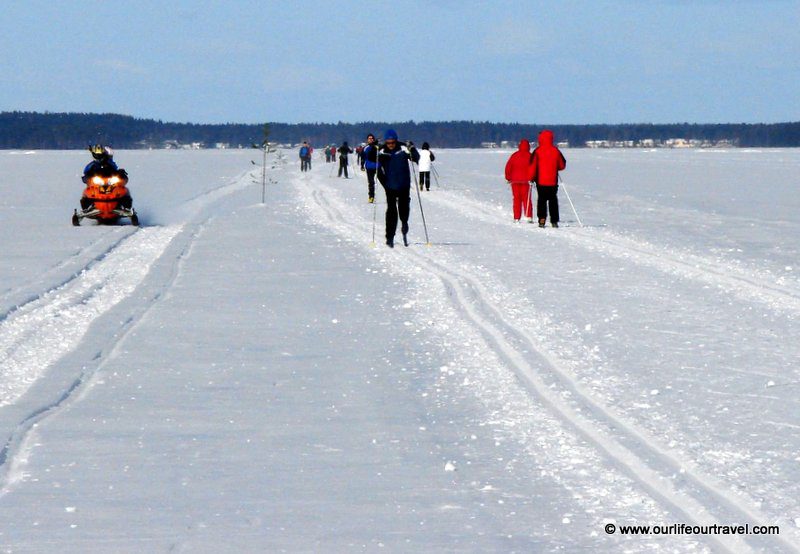Cross-country skiing and a snow mobile on a lake in Finland